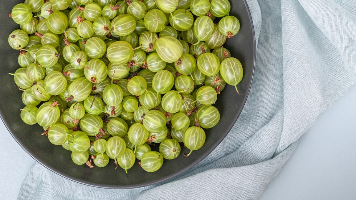 Green amla berries (Indian gooseberries) in a black bowl
